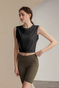 Detail of loose fit sleeveless sports vest and high waist olive green cycling shorts