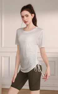 Detail of white yoga t-shirt with adjustable drawstring side and olive green cycling shorts