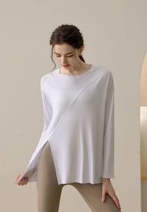 Detail of white long-sleeved yoga top featuring side split hem and asymmetric seam