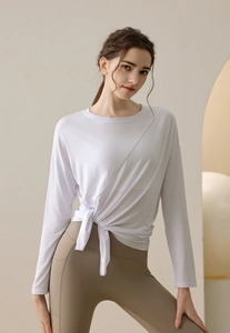 Detail of white modal sports top featuring asymmetric drawstring waist and loose long sleeves
