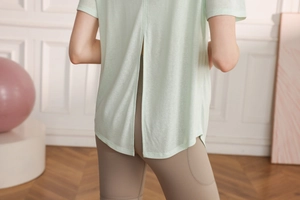 Detail of light green yoga top featuring a breathable split back design and airy fabric