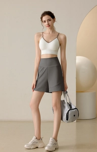Women's white ribbed sports bra and loose grey high-waist shorts set for gym and yoga