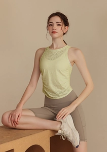 Detail of light green jacquard yoga vest showing breathable fabric and side drawstring ruching