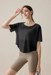 Detail eines locker sitzenden, schwarzen Yoga-T-Shirts mit Netzstruktur und Saum