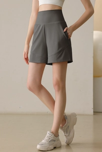 Close-up of high-waisted dark grey sports shorts with side pocket and wide-leg cut