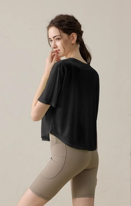 Details vom schwarzen Yoga-T-Shirt mit Rundsaum und beigen High-Waist-Shorts mit Seitentaschen