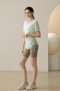 Detail of light green short sleeve yoga top with adjustable side drawstring hem