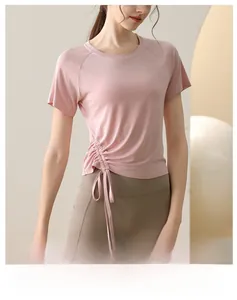 Detail view of pink yoga top showing side drawstring and breathable sports fabric texture