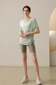 Detail of light green yoga top with side drawstrings and high waist cycling shorts
