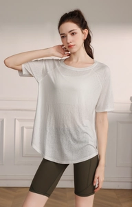 Close-up of white breathable yoga top with split hem and sheer moisture-wicking fabric