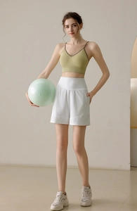Women's avocado green sports bra and white loose running shorts set for yoga and fitness