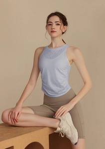 Detail of light blue sleeveless yoga top and khaki high waist sports shorts on a model