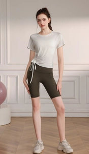 Detail of white sports t-shirt with side drawstring ruching and olive green biker shorts