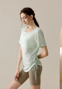 Detail of light green yoga top featuring adjustable side drawstring and breathable fabric