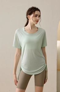 Detail of light green yoga top featuring side drawstring ruching and breathable fabric