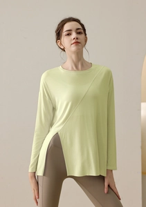 Detail of light green yoga top featuring unique asymmetric seams and high side slit design