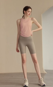 Detailed front view of a women's pale pink slim fit yoga tank top with olive green shorts