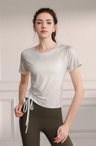 Detail of cream yoga top with side drawstring design and high waist olive leggings