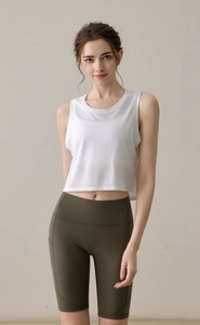Détail d'un crop top en mesh blanc et d'un short vert à taille haute avec poches