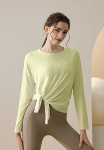 Detail of light green modal sports top featuring a stylish front-cross knotted hem design