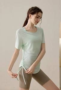 Detail of mint green yoga T-shirt featuring side drawstring ruched hem and breathable fabric