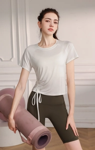 Detail of drawstring yoga top with side ruching and green high waist cycling shorts