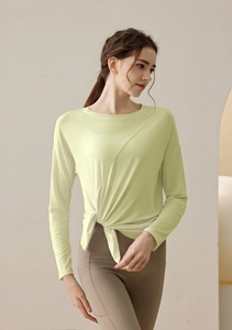 Detail of light green modal sports top featuring a stylish asymmetrical twisted knot hem