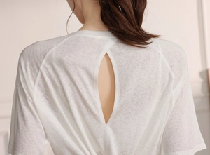 Detailed close-up of white yoga top featuring a stylish teardrop cutout design on back