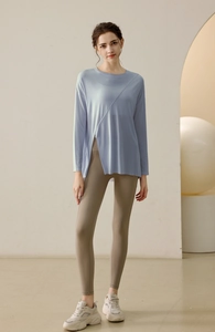 Detail of light blue yoga top featuring asymmetric split hem and breathable fabric texture