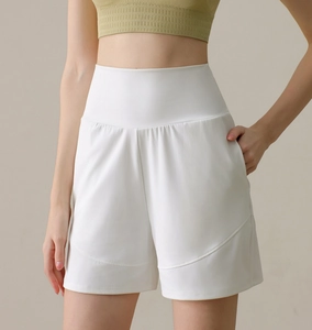 Detail of high-waisted white sports shorts with side pockets and curved stitching accents