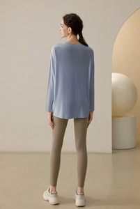 Detail view of loose-fit light blue yoga long sleeve top with side split back design