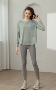 Detailansicht des bohnen grünen Yoga-Oberteils mit grauen Sport-Leggings mit hoher Taille