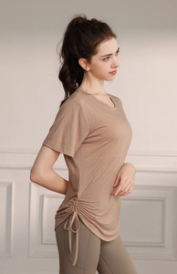 Detail view of the side drawstring adjustment on a loose breathable yoga t-shirt