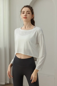 Détail du haut court à manches longues respirant et du legging de yoga gris à taille haute