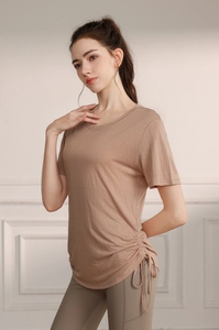 Detail of drawstring cinch design on tencel yoga shirt and olive green leggings