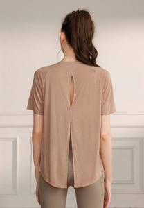 Detail of nude yoga top featuring breathable back cutout and split hem design
