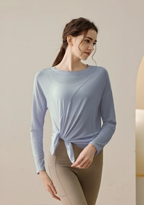 Detail view of light blue modal yoga top with asymmetric knot hem and high waist leggings