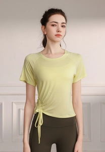 Detail of light yellow yoga top with side drawstring and breathable mesh fabric