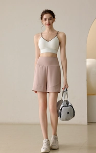 Detailed view of white V-neck sports bra and pink high-waisted wide-leg athletic shorts