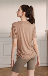 Detail view of the drawstring ruched hem on a breathable coffee-toned yoga t-shirt