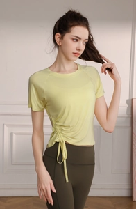 Detail view of women's yellow yoga t-shirt with side drawstring and ruched design