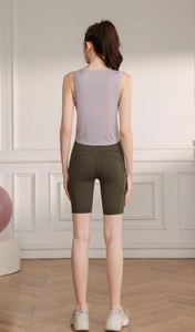 Vue arrière d'une femme en débardeur de sport violet et short de yoga vert olive taille haute