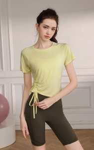 Detail of drawstring side ruching on yellow yoga top and green cycling shorts