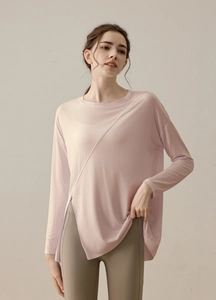 Detail of light pink long sleeve yoga top featuring asymmetrical high side slit hem design