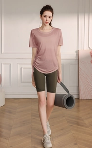 Detailed shot of pink yoga t-shirt with side drawstrings and olive green cycling shorts