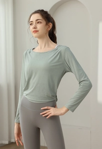 Detail eines jadegrünen Jacquard-Yoga-Oberteils mit grauer High-Waist-Leggings