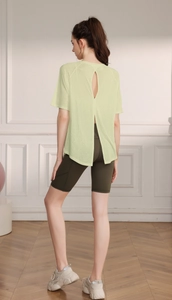 Detail view of the breathable back slit design on a light yellow yoga t-shirt