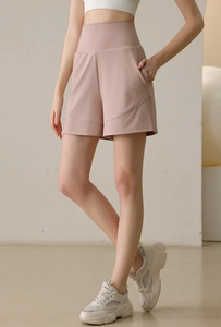Detail view of high waist pink yoga shorts featuring side pockets and loose fit design