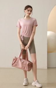 Pink drawstring yoga top and olive green cycling shorts with matching fitness bag