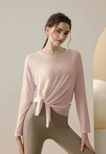 Detail of light pink yoga top with side slit tie waist and athletic leggings with side pocket